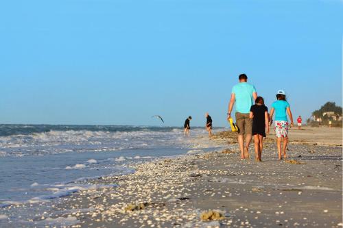 a group of people walking on the beach at Sanibel Inn in Sanibel