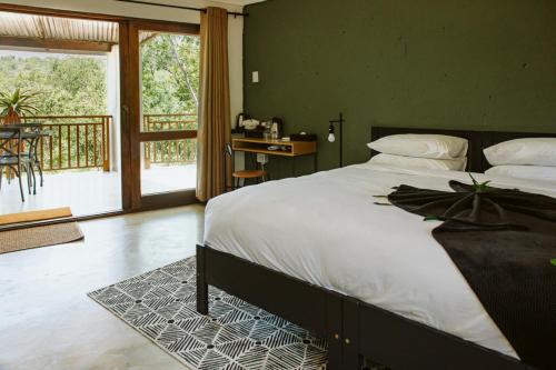 a bedroom with a large bed and a balcony at Matatane Camp - Babanango Game Reserve in Babanango