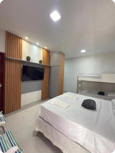 a bedroom with a large bed with white sheets at Flat 11 Condomínio Ibiapaba Camocim in Camocim
