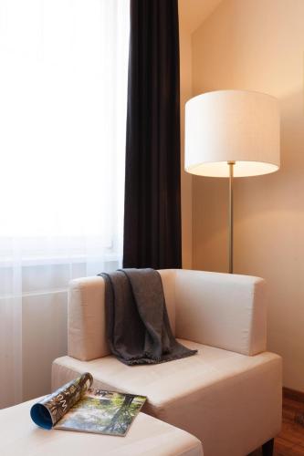 a living room with a couch and a table with a lamp at Vienna House by Wyndham Thüringer Hof Eisenach in Eisenach