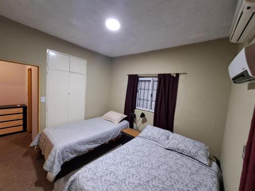 een slaapkamer met twee bedden en een raam bij Alojamiento Marlugm in Corrientes