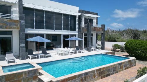 a swimming pool in front of a house at Ocean View Mansion 8 min to Palm Beach in Noord