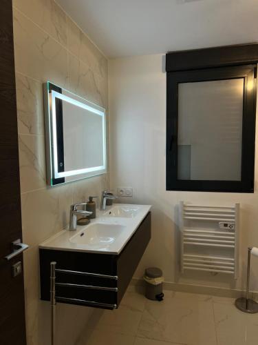 a bathroom with a sink and a mirror at Résidence Les Jardins du Piale in Bonifacio