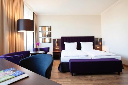 a hotel room with two beds and a television at Vienna House Thüringer Hof Eisenach in Eisenach