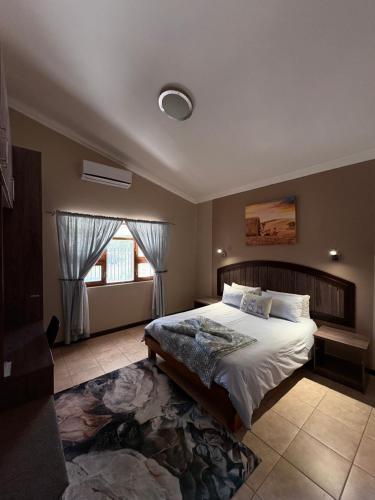 a bedroom with a large bed and a window at Goba Lodge & Rest Camp in Gobabis