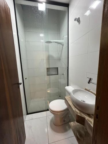 a bathroom with a shower and a toilet and a sink at Beautiful Cozy Beach House Accommodation in Guaratuba