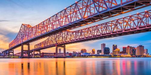 a bridge over the water with a city in the background at Roami at Canal Quarters in New Orleans