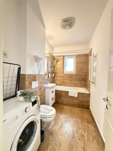 a bathroom with a toilet and a sink and a tub at Luxury Apartments Newton by GLAM - Parking Option in Iaşi