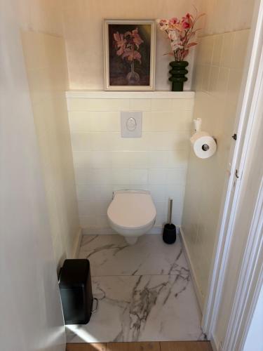 a bathroom with a marble floor and a toilet at Bed & Breakfast Anna in Groningen