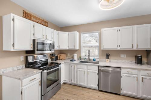 a kitchen with white cabinets and stainless steel appliances at Tusculum Hilltop Haven For 8 in Cincinnati