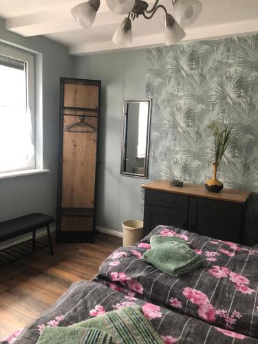 a bedroom with a bed and a dresser and a mirror at FeWo M Becker in Athenstedt