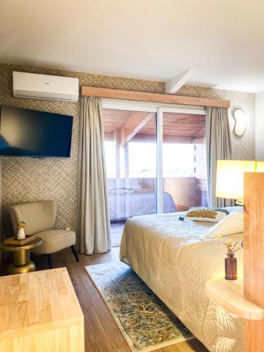 a bedroom with a bed and a sliding glass door at Château le Bouïs Hotel & Wine in Gruissan