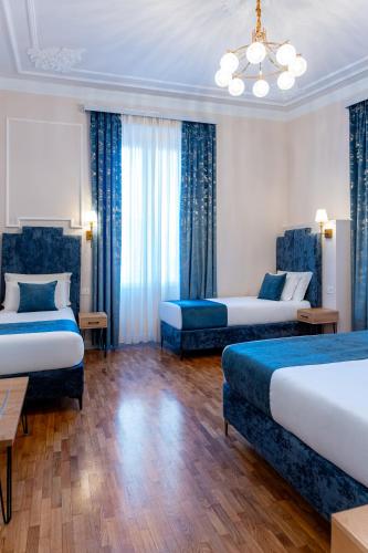 a hotel room with two beds and a chandelier at Fiume 20 - Residence in Florence