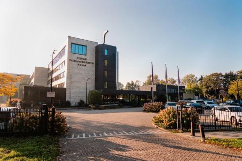 a building with a parking lot in front of it at Van Der Valk Hotel Rotterdam Nieuwerkerk in Nieuwerkerk aan den IJssel