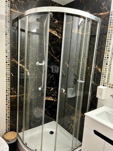 a shower with a glass enclosure in a bathroom at Uslugi hotelowe A1 in Łódź