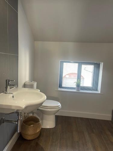 a white bathroom with a toilet and a sink at The Turret, Central Apartment in Hebden Bridge