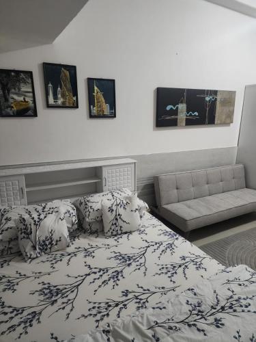 a bedroom with a bed with pillows and a couch at Apartment in ajman in Ajman 