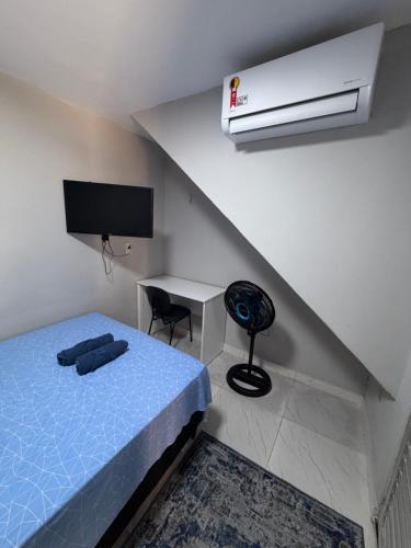 a bedroom with a blue bed and a air conditioner at AmazHost - Casa azul próxima da Basílica de Nazaré in Belém