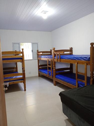 a room with three bunk beds and a window at Chácara Mirante das Colinas in Atibaia