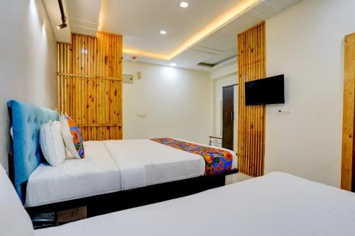a hotel room with two beds and a flat screen tv at Via Blissful Stays in Mumbai