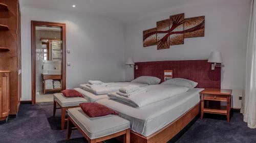 een slaapkamer met 3 bedden, een bureau en een spiegel bij Sportschule Oberhaching in Oberhaching