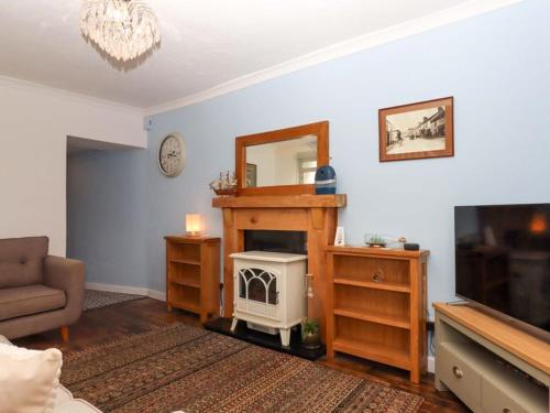 a living room with a fireplace and a television at Kenny cottage - 1 The Court in Dawlish
