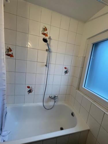 a bath tub with a shower head in a bathroom at Ferienwohnung Emma in Castrop-Rauxel
