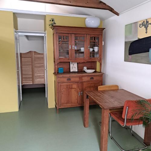 a kitchen with a wooden cabinet and a wooden table at Klein huisje in het centrum in Apeldoorn
