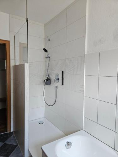 a white bathroom with a shower and a sink at Ferienwohnung Apfelbaum Kitzingen in Kitzingen