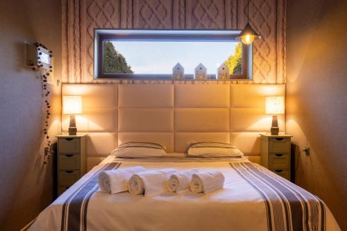 a bedroom with a bed with two towels and a window at Positano Apartment in Głowno