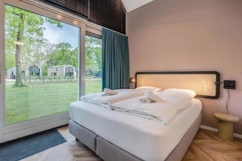 a bedroom with a bed and a large window at Landal Olde Kottink in Beuningen