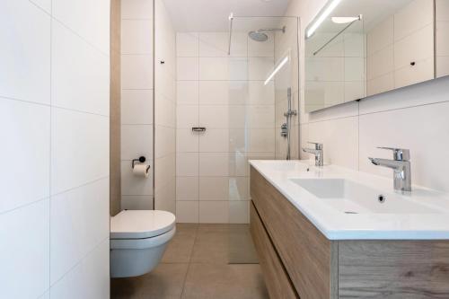 a white bathroom with a sink and a toilet at Landal Olde Kottink in Beuningen