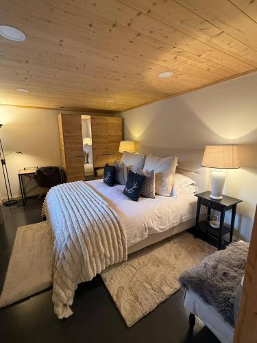 a bedroom with a large bed with a wooden ceiling at Little Chalet Piguet in Gryon