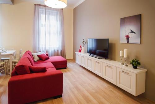 プラハにあるApartment Za Poricskou branouのリビングルーム(赤いソファ、薄型テレビ付)