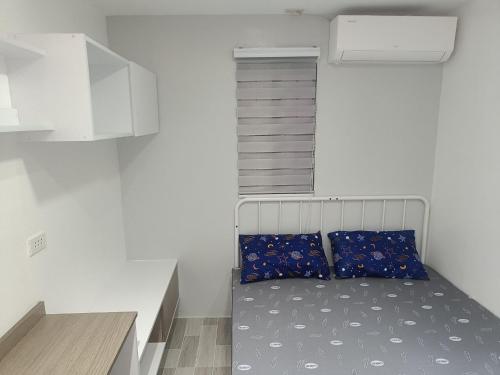 a small bedroom with a bed in a room at Charming 2-Bedroom Balanga Getaway with Ample Space in Balanga