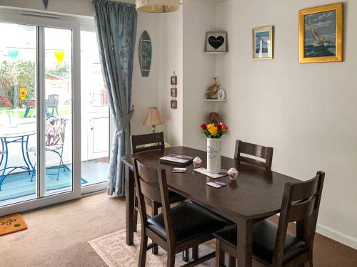 a dining room with a wooden table and chairs at The Hollies in Weston-super-Mare
