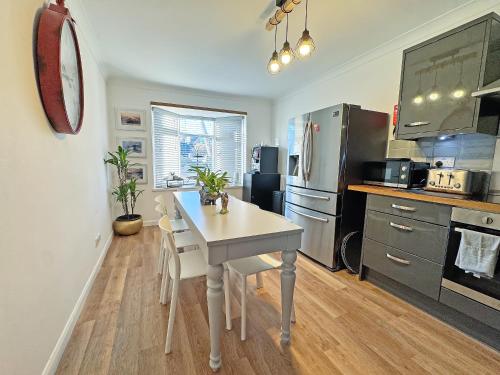 een keuken met een tafel en een keuken met een koelkast bij The Annexe in Peacehaven