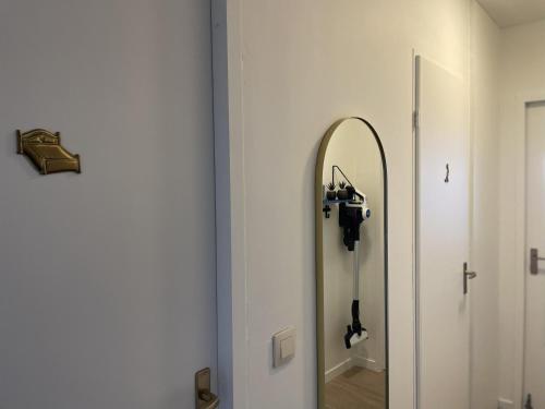 a mirror on a wall next to a hallway at Golden Sun in Middelkerke