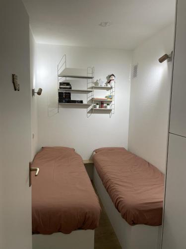 a small room with two beds and a shelf at Golden Sun in Middelkerke