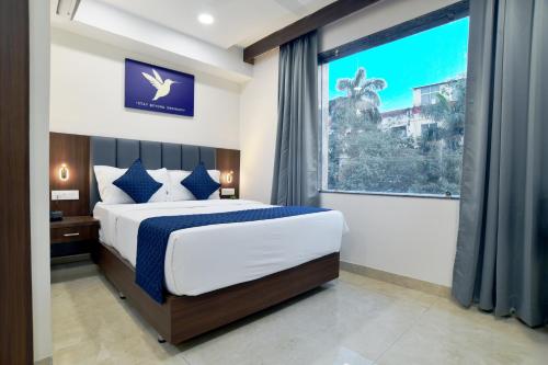 a bedroom with a bed and a large window at Nyotel-MP Nagar Bhopal in Bhopal