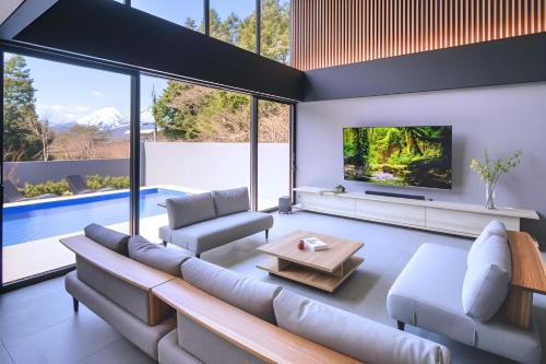 a living room with a couch and a tv at Villa Cielo Hakone Luxury - Mt Fuji View Private Onsen & Sauna シエロ箱根仙石原 in Hakone
