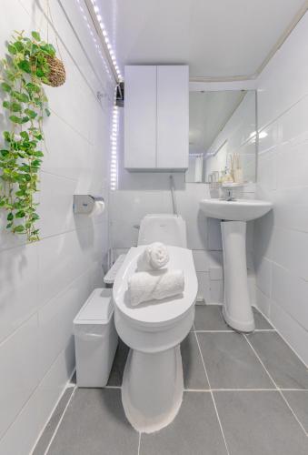 a white bathroom with a toilet and a sink at 홍대 stay yoo - Hongdae 3min Station Cozy House in Seoul