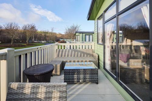 a porch with a bench and a table on a balcony at Host and Stay - 421 Wooler Park in Wooler