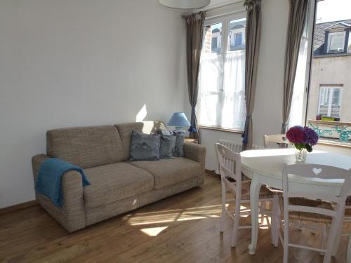 un salon avec un canapé et une table dans l'établissement Le Charme à la Française, à Honfleur