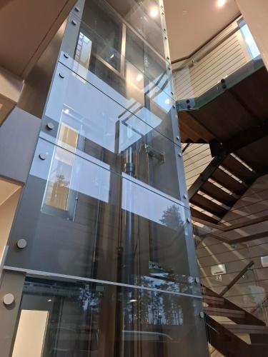 a glass wall in a room with a staircase at Naava Chalet 401 Penthouse - Järvinäköala ilta-aurinkoon in Ähtäri