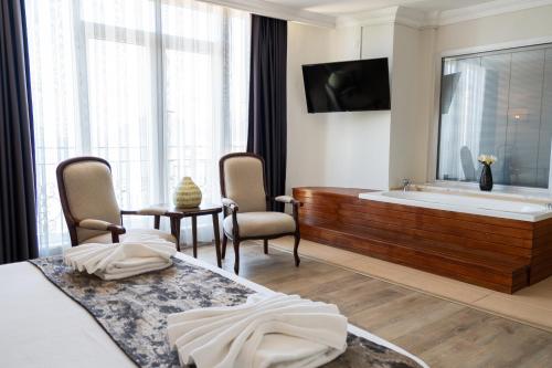 ein Schlafzimmer mit Badewanne, Bett und Fernseher in der Unterkunft Hotel Caprea in Marmaris