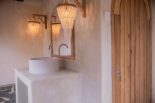 a bathroom with a sink and a mirror and lights at Pachamama Pool Villa in Gili Islands
