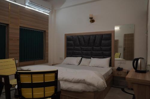 a bedroom with a large bed with a desk and a desk at Yatindra Ashraya in Etāwah