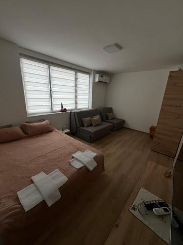 a bedroom with a large bed and a couch at Stan na dan Žabac in Vlasenica