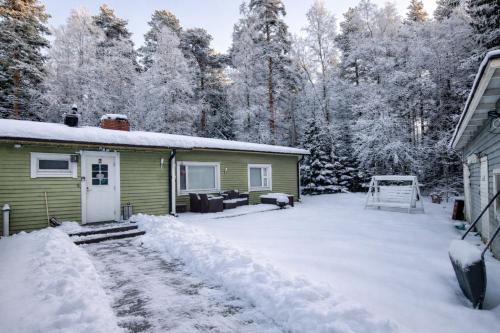 a yard covered in snow next to a house at Lumi & Luonto - Entire 100 sqm 3-BR house with private wood fired sauna in Oulu
